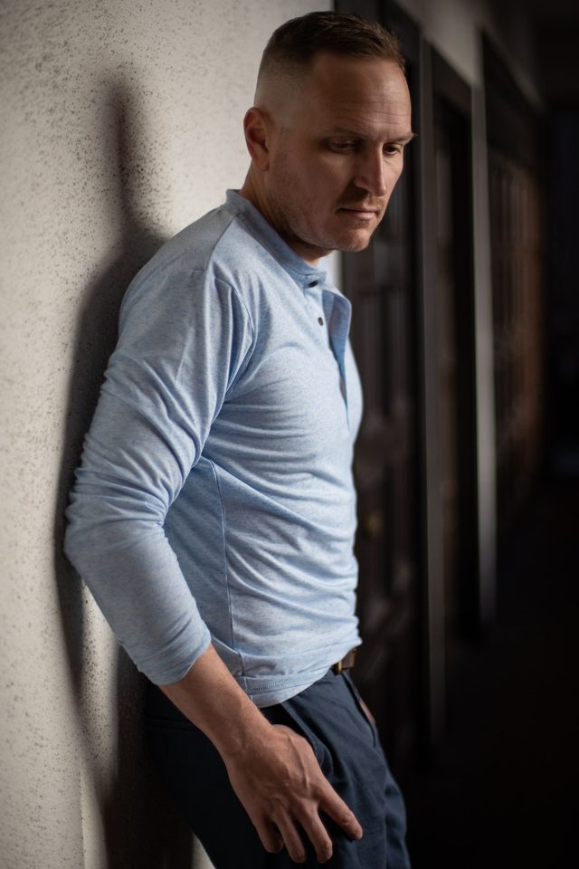 Dating profile photo example: client in dramatic window light against a wall